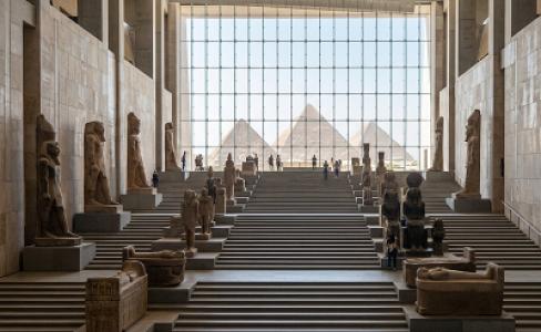 The Grand Staircase showcasing ancient pharaonic statues aligned towards the Giza Pyramids