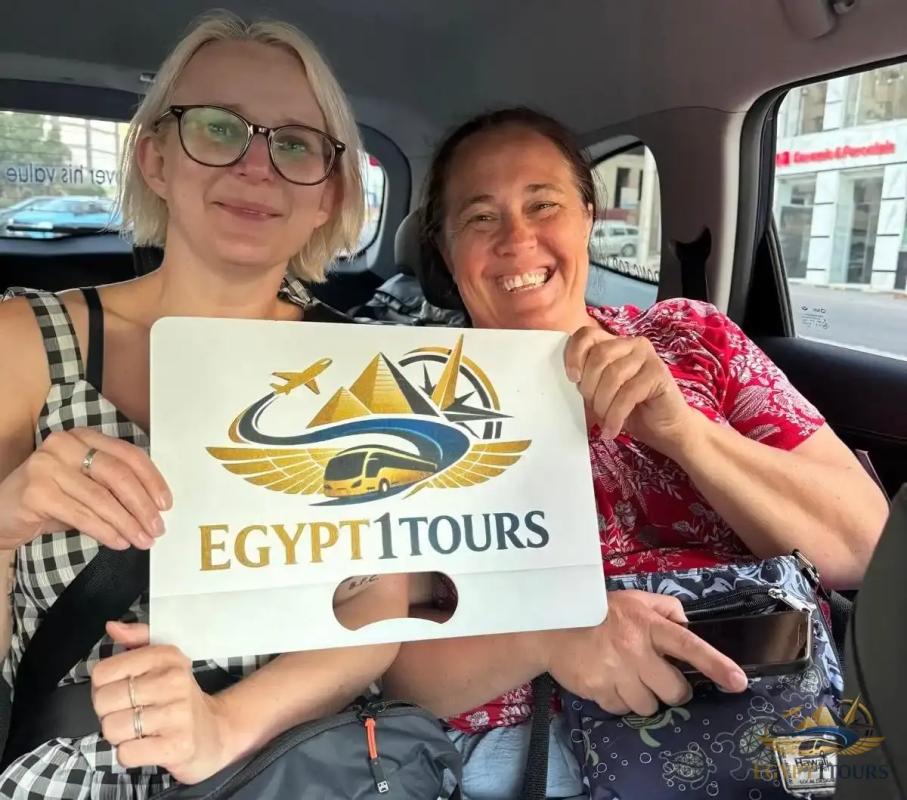 Tourists relaxing inside private car holding Egypt 1 Tours sign during transfer from Cairo to Hurghada