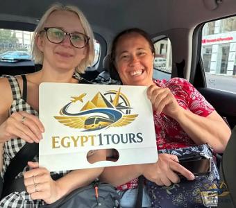 Tourists relaxing inside private car holding Egypt 1 Tours sign during transfer from Cairo to Hurghada